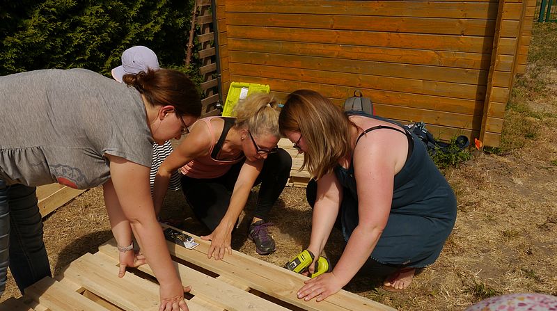 Frauen bauen eine Bank für die Kita